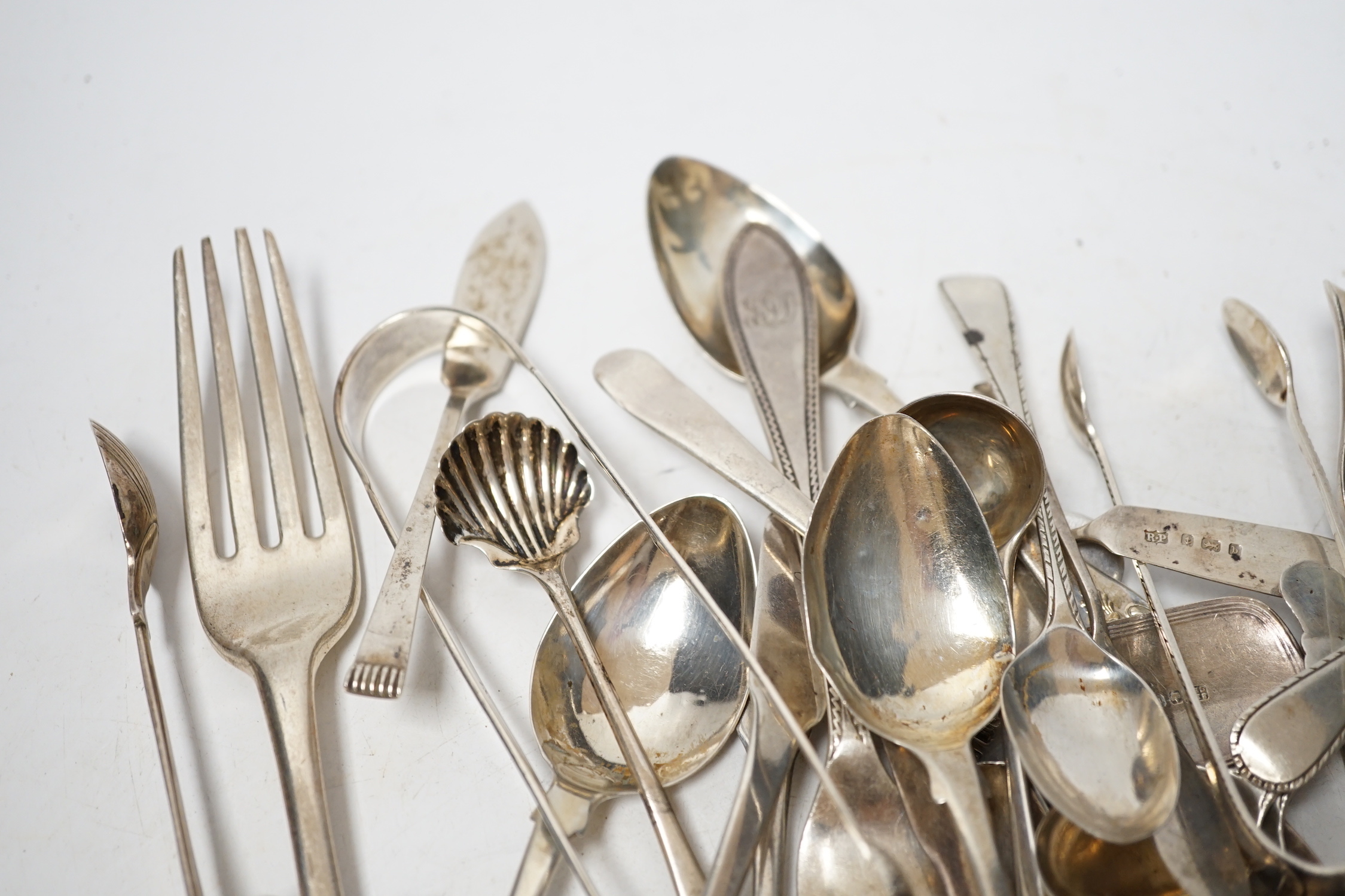 A small quantity of assorted 19th century and later silver flatware, two white metal spoons and a Victorian 'Rum' wine label, 18.2oz.